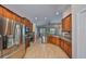 Open kitchen featuring stainless steel appliances, light wood floor, and dark cabinetry at 5124 Clover Mist Dr, Apollo Beach, FL 33572