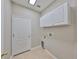 Laundry room featuring tile floors, white cabinets, neutral paint and a utility sink at 5124 Clover Mist Dr, Apollo Beach, FL 33572