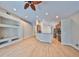Bright living room with wood floors, built-in shelving, and open layout to kitchen at 5124 Clover Mist Dr, Apollo Beach, FL 33572