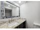 Modern bathroom featuring tile flooring, toilet, and a mirror over granite countertops at 6141 Chesham Dr # 7, New Port Richey, FL 34653