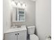 Cozy powder room featuring a toilet, modern mirror, fresh paint, and a sink at 6141 Chesham Dr # 7, New Port Richey, FL 34653