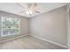 This vacant bedroom features modern laminate floors, a ceiling fan, and large window at 6141 Chesham Dr # 7, New Port Richey, FL 34653