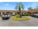 Condo complex featuring a central palm tree, landscaping, and ample parking at 6141 Chesham Dr # 7, New Port Richey, FL 34653