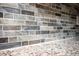 Close up of the beautiful neutral toned mosaic backsplash with the look of stone and the granite countertops at 6141 Chesham Dr # 7, New Port Richey, FL 34653
