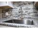 Modern kitchen featuring a stainless steel sink, granite countertops, and attractive backsplash at 6141 Chesham Dr # 7, New Port Richey, FL 34653