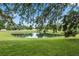Scenic view of a pond reflecting blue skies and framed by mature trees at 6141 Chesham Dr # 7, New Port Richey, FL 34653