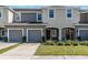 Inviting townhome featuring an attached garage, manicured lawn and neutral paint scheme, offering great curb appeal at 7060 Woodchase Glen Dr, Riverview, FL 33578