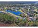 Beautiful aerial view of a residential neighborhood featuring well-maintained homes and a scenic pond at 10105 Holly Berry Dr, Weeki Wachee, FL 34613