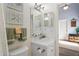 Well-lit bathroom featuring a vanity sink, large mirror, and calming nautical decor at 10105 Holly Berry Dr, Weeki Wachee, FL 34613