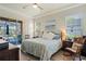 Bright bedroom features a queen bed, ensuite sliding glass door to screened patio and backyard pool at 10105 Holly Berry Dr, Weeki Wachee, FL 34613