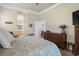Cozy bedroom features a queen bed, wood furniture, and a view into the ensuite bathroom at 10105 Holly Berry Dr, Weeki Wachee, FL 34613