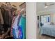 Organized walk-in closet with clothing racks and shelves; bedroom view with ceiling fan at 10105 Holly Berry Dr, Weeki Wachee, FL 34613