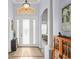 Bright foyer featuring a glass-paneled front door, elegant decor, and views into the living spaces at 10105 Holly Berry Dr, Weeki Wachee, FL 34613