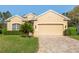 Charming home with a two-car garage, brick driveway, well-manicured lawn and verdant shrubbery at 10105 Holly Berry Dr, Weeki Wachee, FL 34613