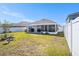 View of the manicured lawn, screened in lanai, and backyard at 1014 Coastal Hammock Ave, Ruskin, FL 33570