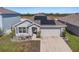 Attractive single-story home with manicured lawn, solar panels, and a two-car garage at 1014 Coastal Hammock Ave, Ruskin, FL 33570