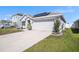 A well-maintained home featuring a two-car garage, solar panels, and a lush green lawn at 1014 Coastal Hammock Ave, Ruskin, FL 33570