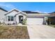 Charming one-story home featuring a well-manicured lawn, two car garage, and solar panels on the roof at 1014 Coastal Hammock Ave, Ruskin, FL 33570