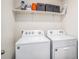 Functional laundry room with a washer, dryer, and shelving for storage at 1014 Coastal Hammock Ave, Ruskin, FL 33570