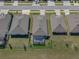 Aerial view of a well-maintained home featuring a screened-in pool, fenced yard, and manicured lawn at 13359 Golden Lime Ave, Spring Hill, FL 34609