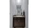 Powder room features a dark wood vanity with granite countertop and single sink at 13359 Golden Lime Ave, Spring Hill, FL 34609