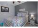 Bedroom features a bed with a colorful quilt, bedside table with lamp, and gray accent wall at 13359 Golden Lime Ave, Spring Hill, FL 34609