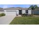 Beautiful single-story home with a manicured lawn, light grey garage door, and stone veneer accents at 13359 Golden Lime Ave, Spring Hill, FL 34609
