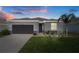 Charming single-Gathering home with a well-maintained lawn, dark grey garage door, and stone accents at 13359 Golden Lime Ave, Spring Hill, FL 34609