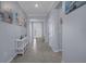 Long hallway with neutral tile flooring, decorative paintings, and lots of natural light at 13359 Golden Lime Ave, Spring Hill, FL 34609