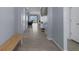 Long hallway with neutral tile flooring, leading to living area, and lots of natural light at 13359 Golden Lime Ave, Spring Hill, FL 34609