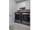Laundry room with white cabinets over the side by side washer and dryer at 13359 Golden Lime Ave, Spring Hill, FL 34609