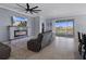 Comfortable living room with fireplace, tile flooring, large ceiling fan, and sliding glass doors at 13359 Golden Lime Ave, Spring Hill, FL 34609