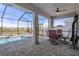 Relaxing screened-in patio featuring a pool, a dining set, and views of the green space at 13359 Golden Lime Ave, Spring Hill, FL 34609