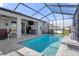 Enjoy the sun and fun in this screened-in pool with an adjacent patio and green space at 13359 Golden Lime Ave, Spring Hill, FL 34609