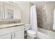 Neutral bathroom featuring granite vanity, mosaic tile accents, and bathtub with shower at 138 Edgewater Ter, Dunedin, FL 34698
