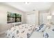 Bright bedroom with large window, closet and beach-themed bedding with white furniture at 138 Edgewater Ter, Dunedin, FL 34698