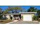 Charming single-story home with a well-maintained lawn, a one car garage, and a cozy front porch at 138 Edgewater Ter, Dunedin, FL 34698