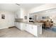 Open kitchen with white cabinets, stainless appliances, and granite counters, flowing to dining area at 138 Edgewater Ter, Dunedin, FL 34698