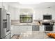 Modern kitchen featuring stainless steel appliances, granite countertops, and white cabinets at 138 Edgewater Ter, Dunedin, FL 34698