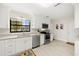 Bright kitchen featuring stainless steel appliances, granite countertops, and white cabinetry at 138 Edgewater Ter, Dunedin, FL 34698