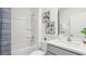 Clean bathroom with a tub and shower combination, white fixtures, and decorative artwork at 17468 Whiskey Creek Trl, Parrish, FL 34219