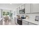 Modern kitchen features stainless steel appliances, white countertops and open layout to the dining area at 17468 Whiskey Creek Trl, Parrish, FL 34219