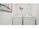 Laundry room with washer, dryer, wire shelving and a sailboat picture on the wall at 17468 Whiskey Creek Trl, Parrish, FL 34219