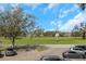 Building exterior with green recreational space, mature landscaping, and designated parking at 2403 Finlandia Ln # 27, Clearwater, FL 33763