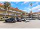 Exterior building view showcasing mature palm trees, red roofing and covered walkways at 2403 Finlandia Ln # 27, Clearwater, FL 33763
