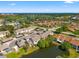 Community aerial view of waterfront homes, a golf course, and the ocean in the distance at 2462 Kingfisher Ln # J203, Clearwater, FL 33762
