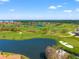 Aerial shot of golf course with beautiful green grass, sand traps, and a pond at 2462 Kingfisher Ln # J203, Clearwater, FL 33762