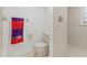 Clean bathroom featuring a toilet, tiled shower, and towel rack with colorful towel at 2462 Kingfisher Ln # J203, Clearwater, FL 33762