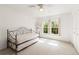 Bright bedroom featuring light carpet, ceiling fan, and double windows with shutters at 2462 Kingfisher Ln # J203, Clearwater, FL 33762