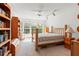 Bright bedroom with bookshelves, windows with shutters, and a ceiling fan at 2462 Kingfisher Ln # J203, Clearwater, FL 33762